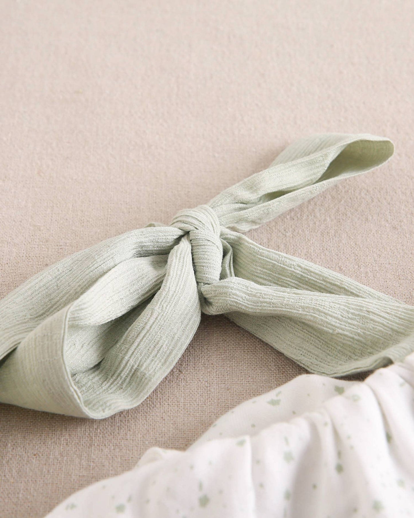 Abito da bambina verde pastello con volant asimmetrico e fiocco