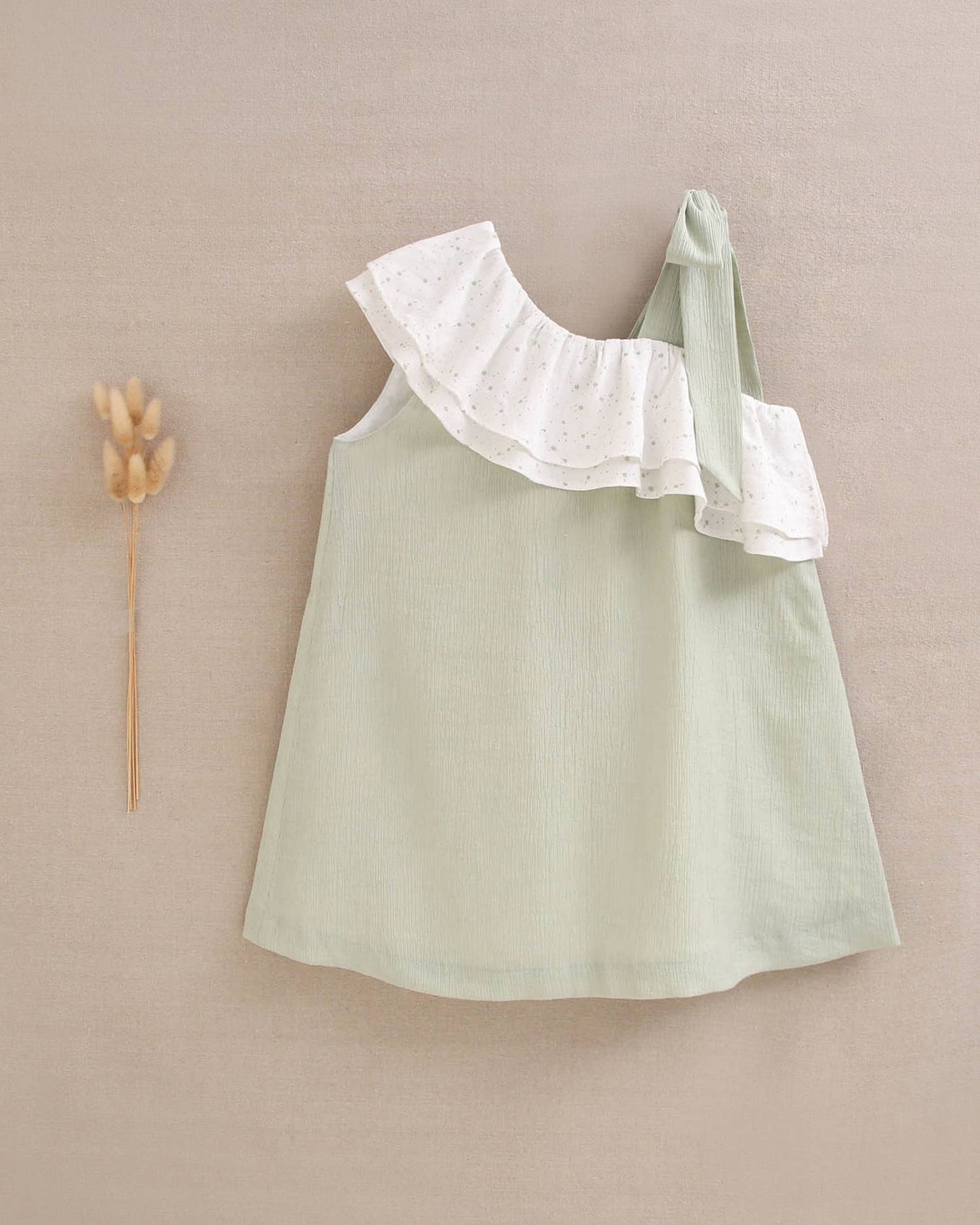 Abito da bambina verde pastello con volant asimmetrico e fiocco