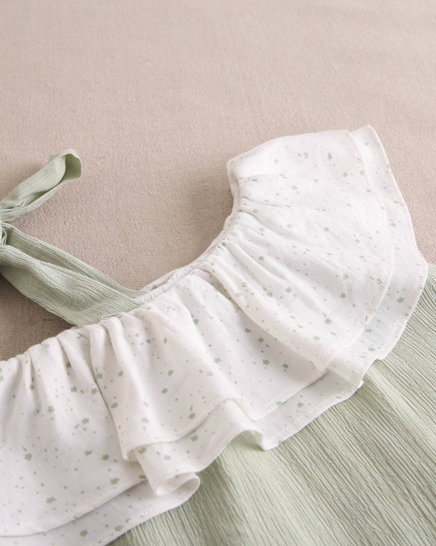 Abito da bambina verde pastello con volant asimmetrico e fiocco